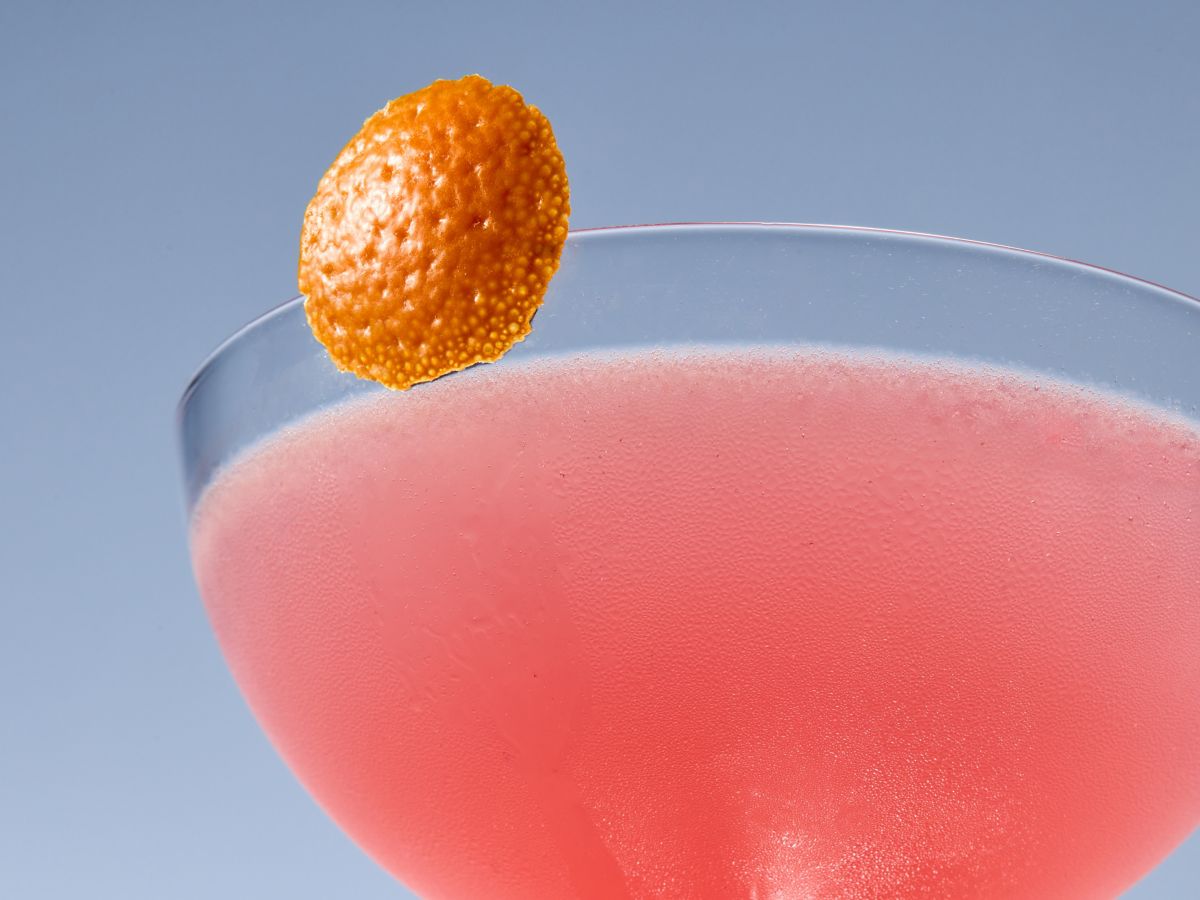 Pink-hued Cosmopolitan Cocktail with orange peel