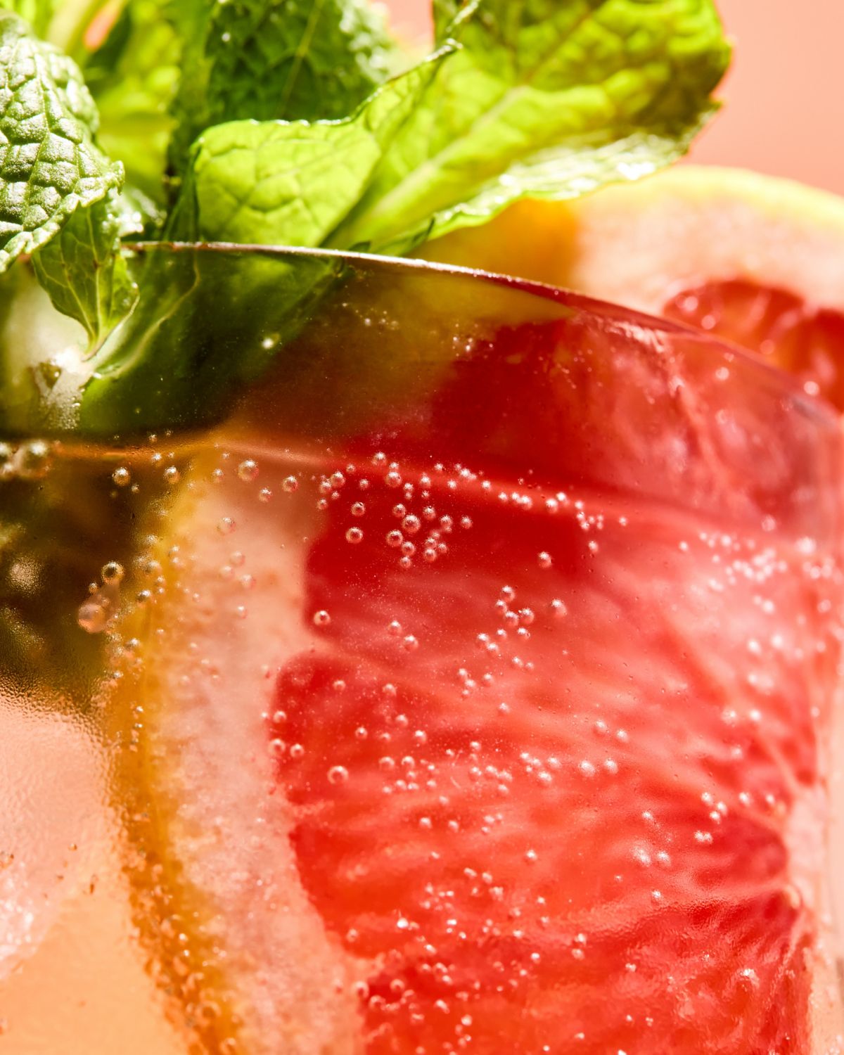 A close-up of the G-Fruit Spritz, garnished with pink grapefruit and mint 