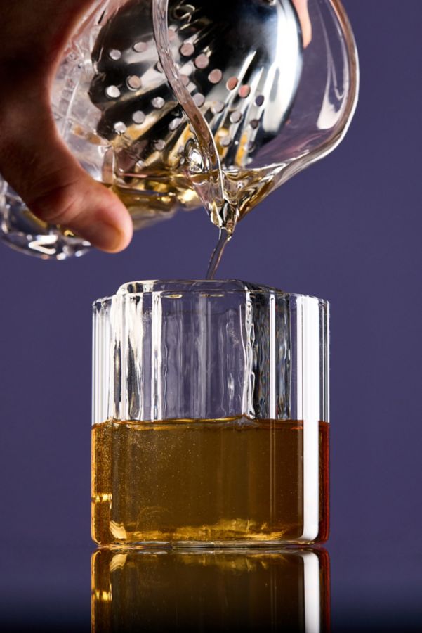 Pouring the Godfather cocktail into a glass