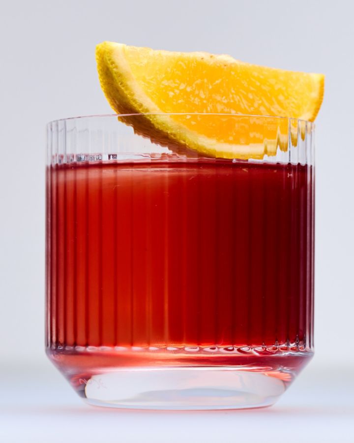 The classic Negroni cocktail is garnished here with an orange wedge 