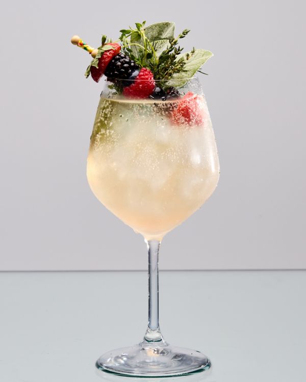 The Non-Alc Berry Spritz with berries and herbs as garnish