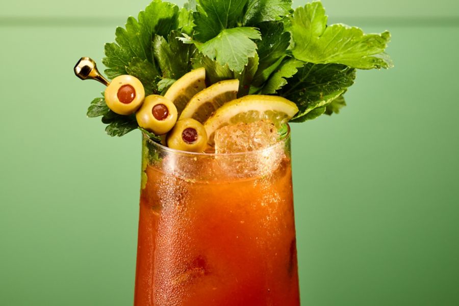 A close-up of the Bloody Mary with olives, lemon and celery as garnish