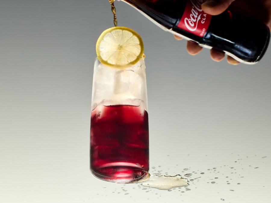 Adding Coca-Cola to glass of red wine to make a Kalimotxo