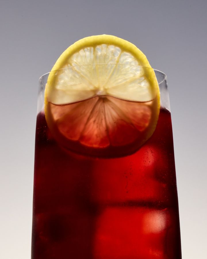 Closeup of the Kalimotxo cocktail, garnished with a lemon wheel