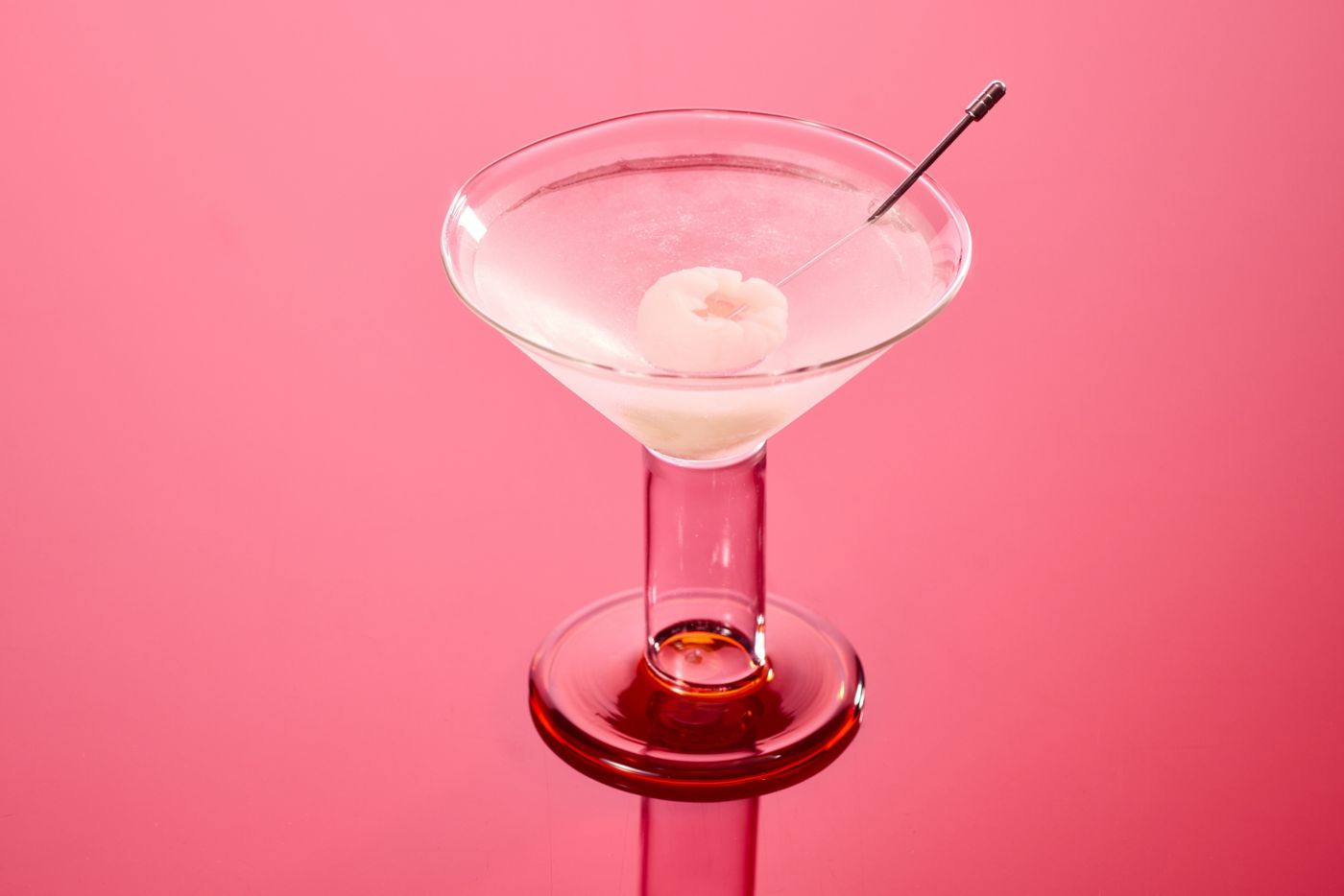 A Lychee Martini on a bright pink background
