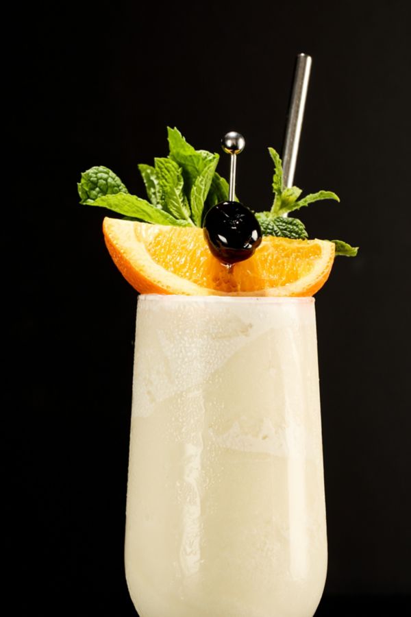 The classic Pina Colada cocktail, garnished with an orange, cherry and mint 