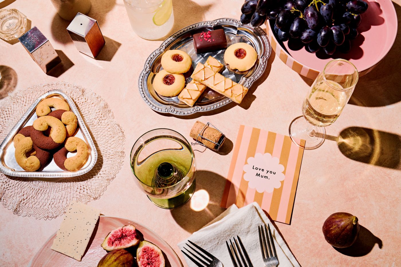 A spread of food and wine with a Mother's Day card on the table 