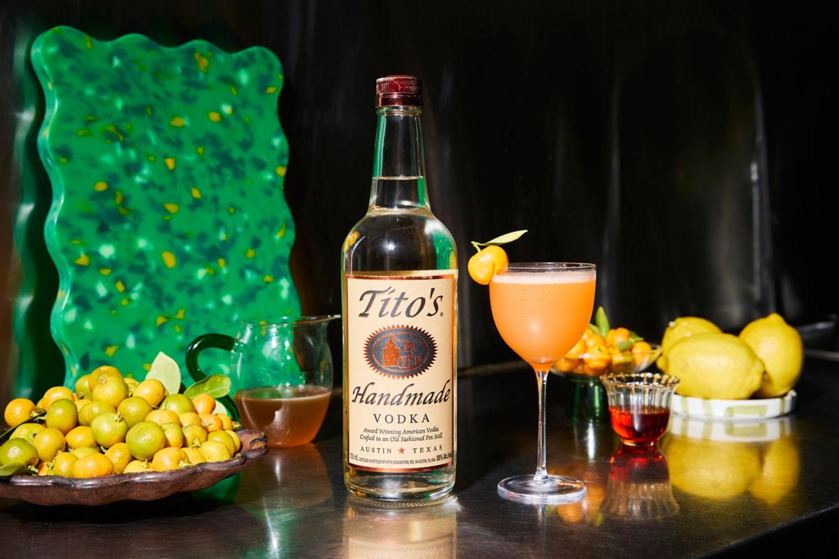 The Cumquat Sour next to a bottle of Tito's Handmade Vodka