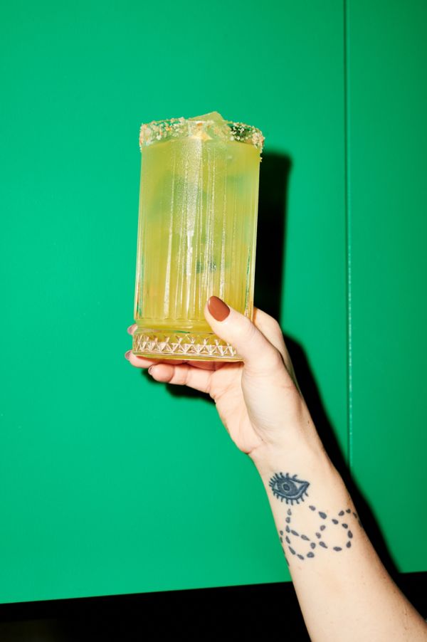 Holding the Imperial Cantarito cocktail in a highball glass