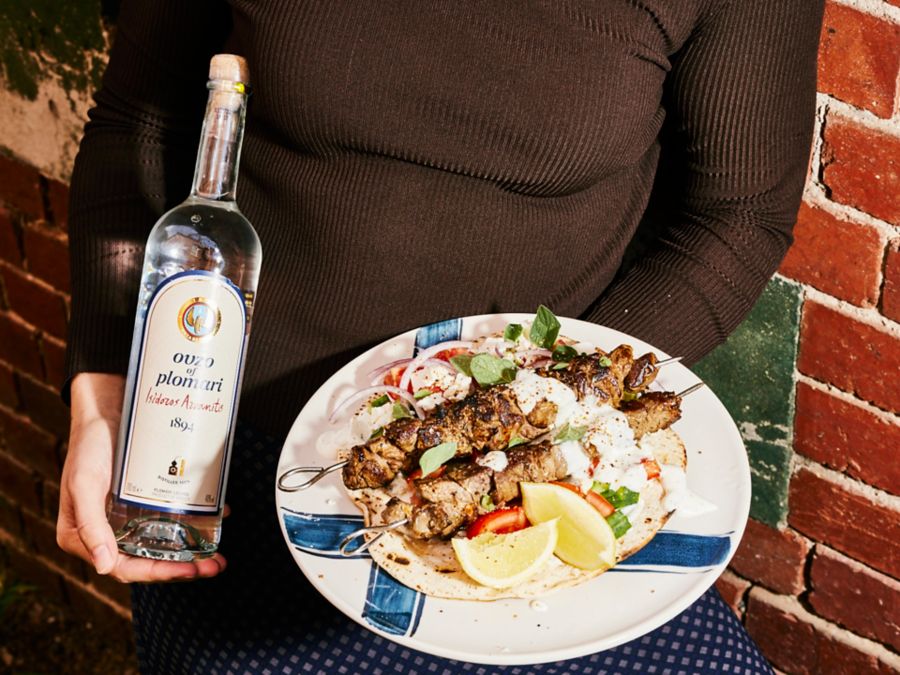Souvlaki on a plate and a bottle of ouzo 
