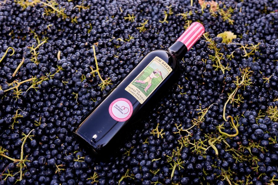 A bottle of Jim Barry wine lying on harvested grapes  