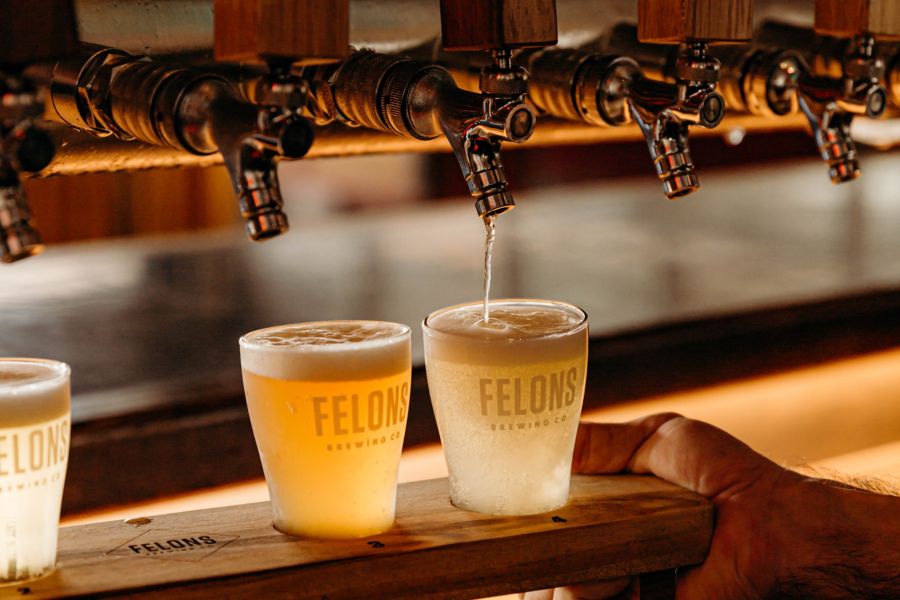 Pouring a tasting paddle of Felons beer 