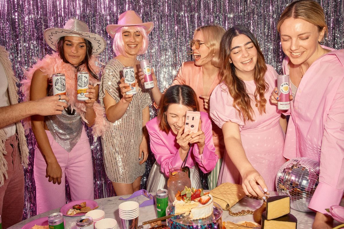Tiny Disco team drinking White Claw seltzers around grazing platter