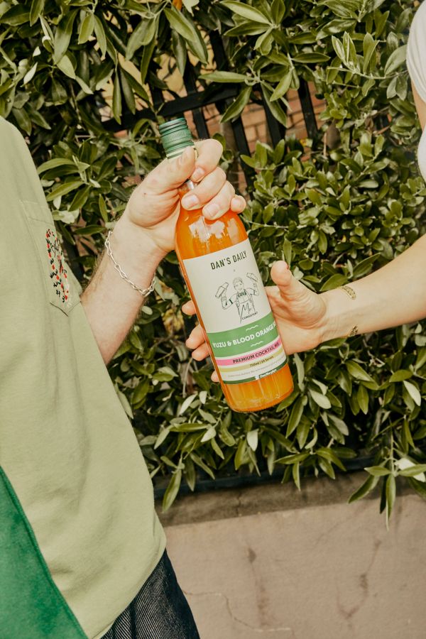 Holding a bottle of Mr Consistent Yuzu & Blood Orange Sour