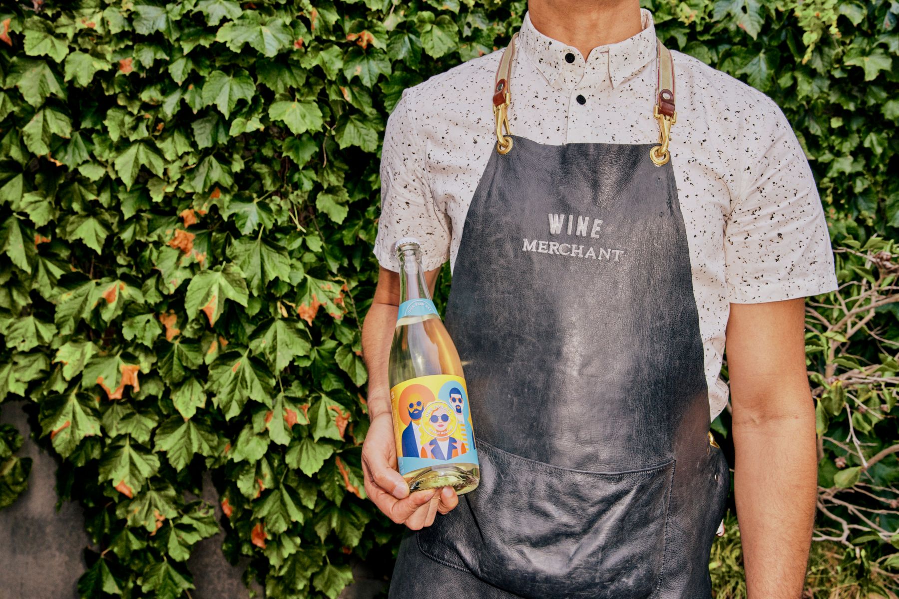 Holding a bottle of One For All Bubbly Moscato