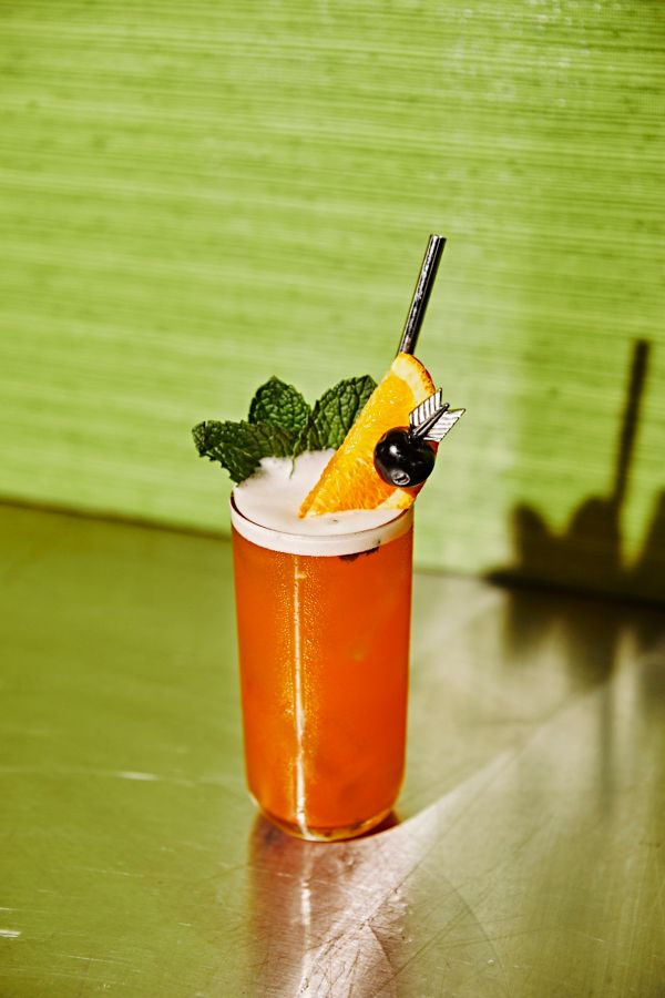 The bright orange Summer in Seoul cocktail, with mint, orange and cherry as garnish  