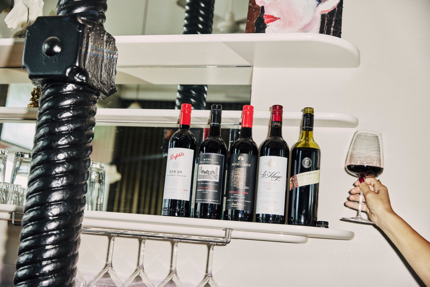 A line-up of older vintages of wine and a glass of red wine