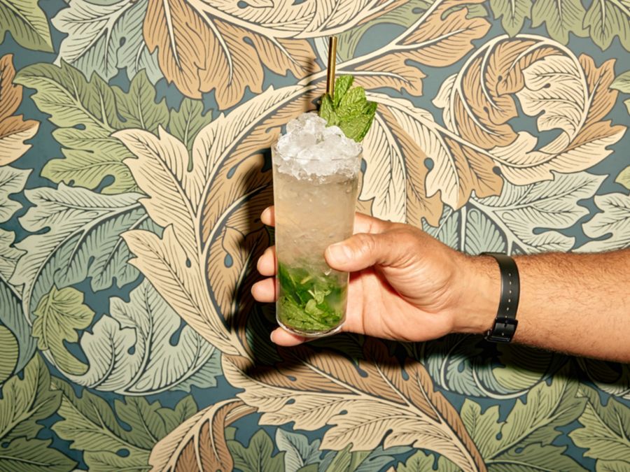 Holding a Mojito, which mixes white rum with lime, mint and soda 