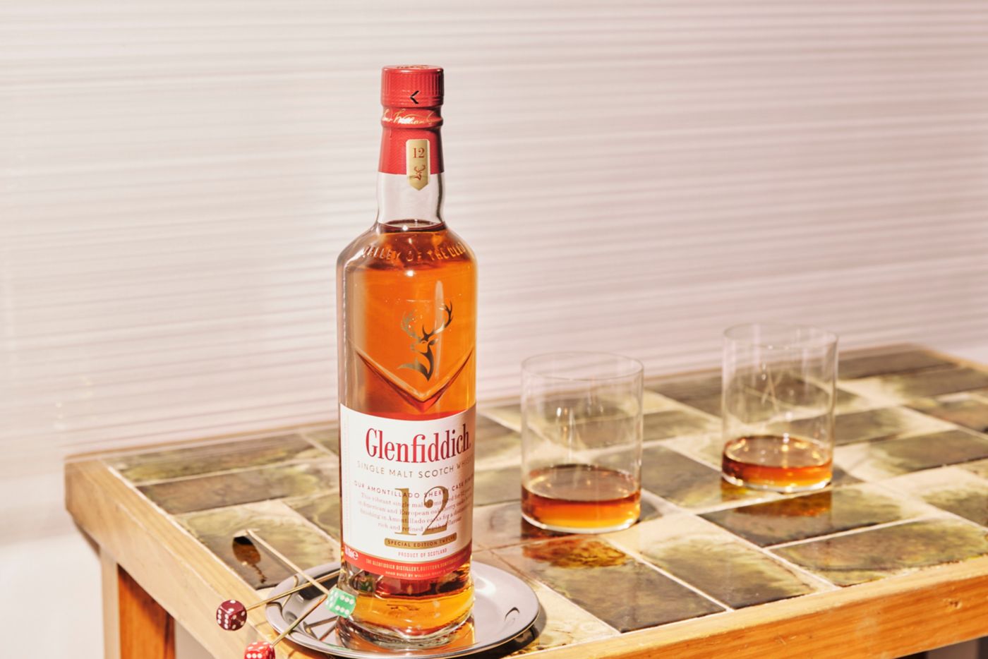 A bottle of Glenfiddich Scotch whisky and a couple of drams in a glass 