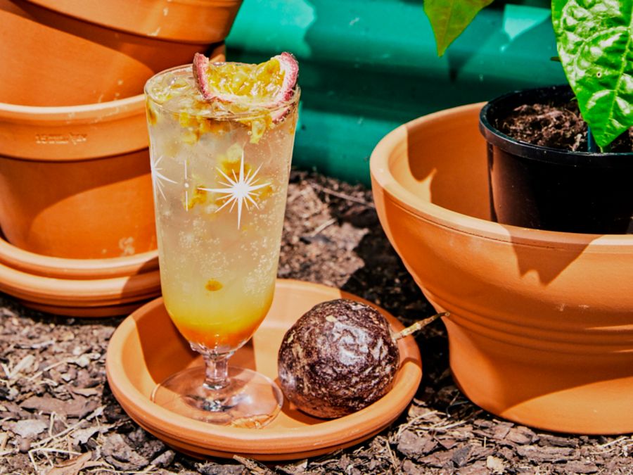 A cocktail garnished with fresh passionfruit