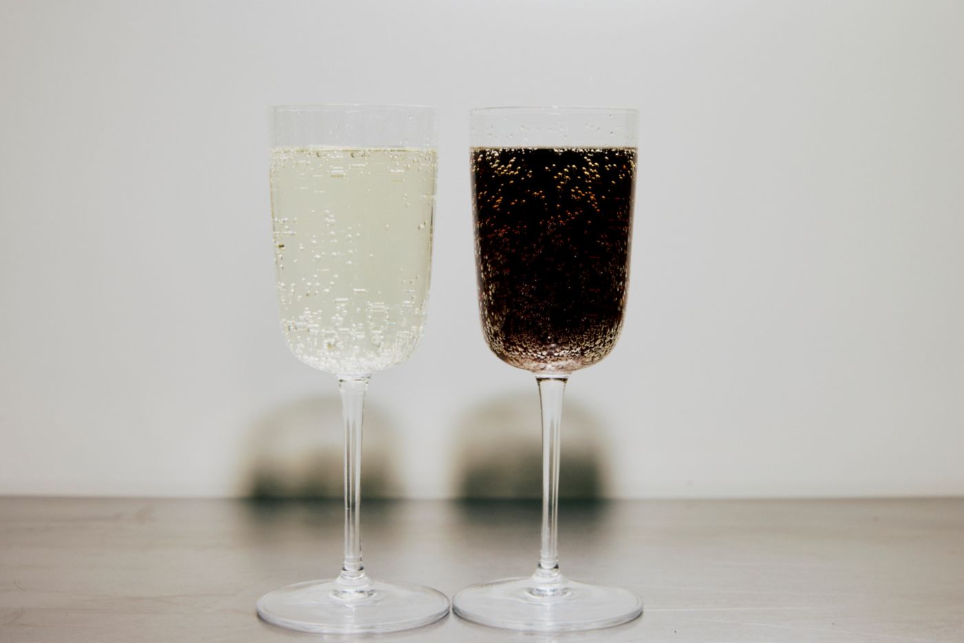 A glass of Diet Coke and sparkling wine next to each other