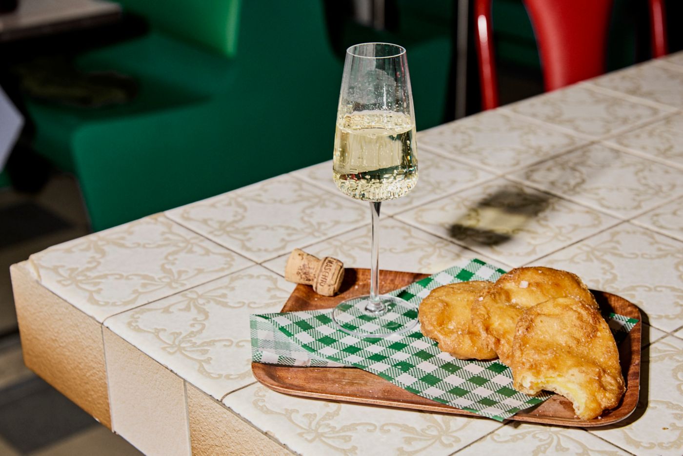 A glass of sparkling with some deep-friend potato cakes