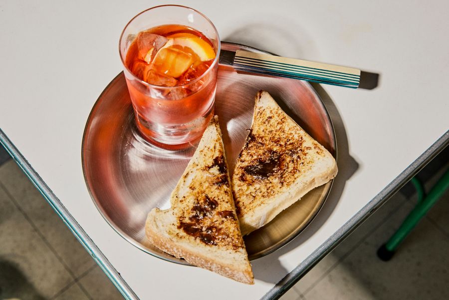 Vegemite toast on a plate with a Negroni