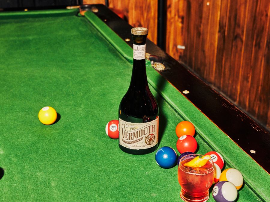 A bottle of Ambrosia Vermouth on a pool table
