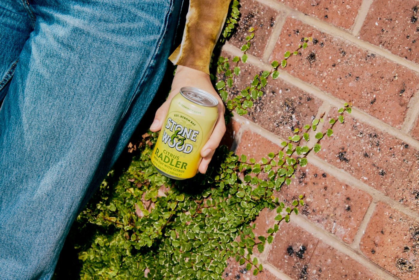 Holding a can of Stone & Wood Citrus Radler in a garden