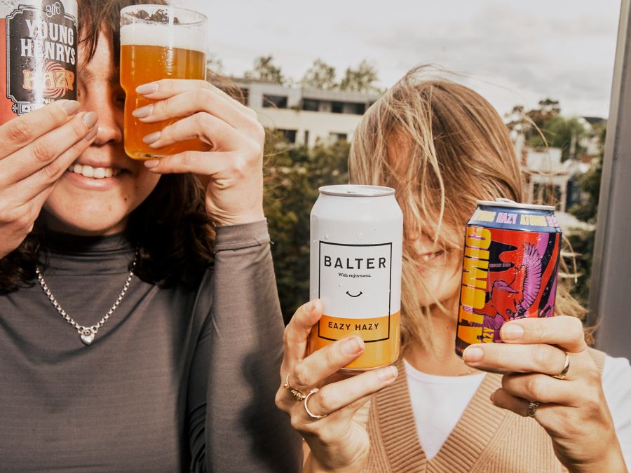 Holding cans of hazy IPA