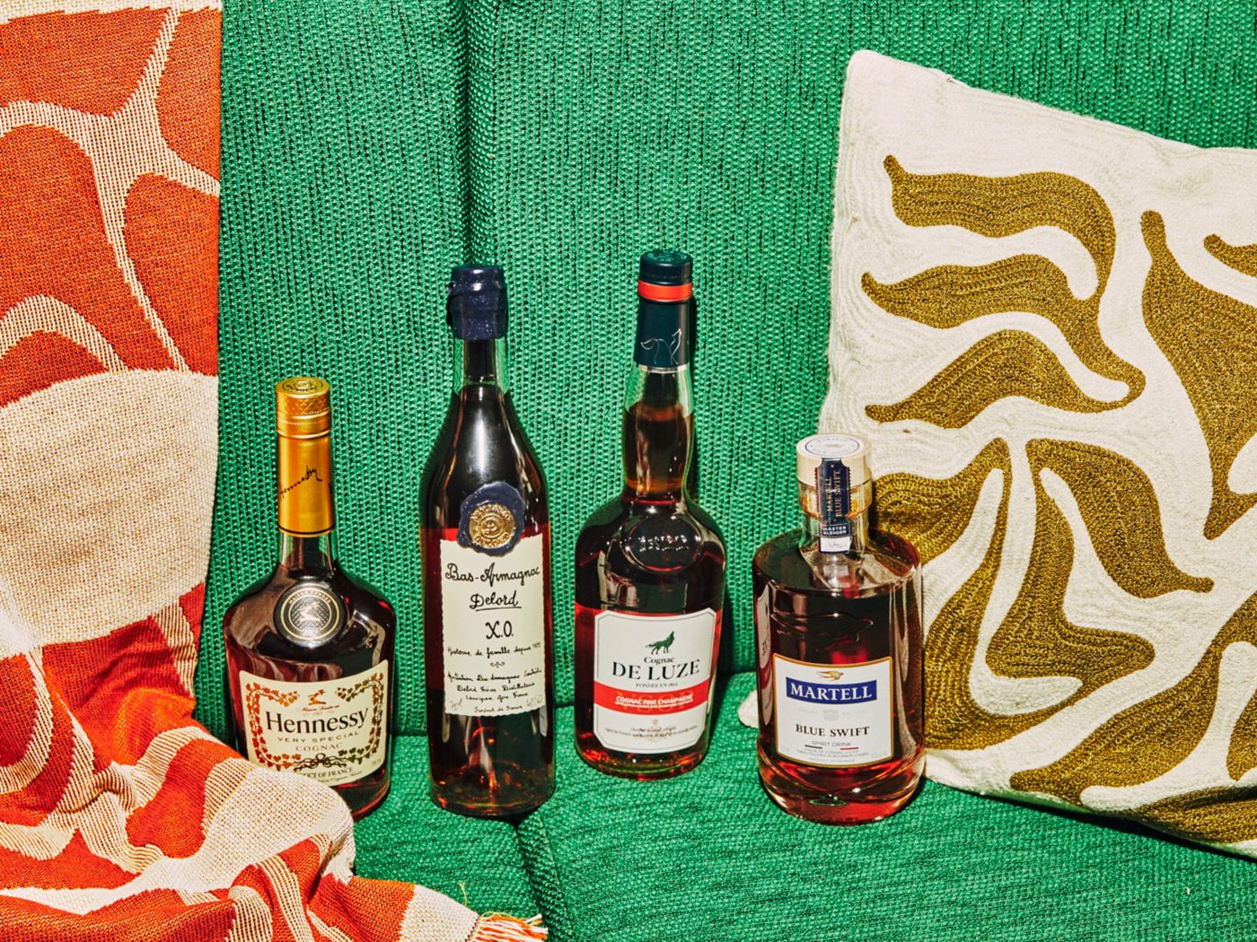 Several bottles of Cognac on a bright green sofa 