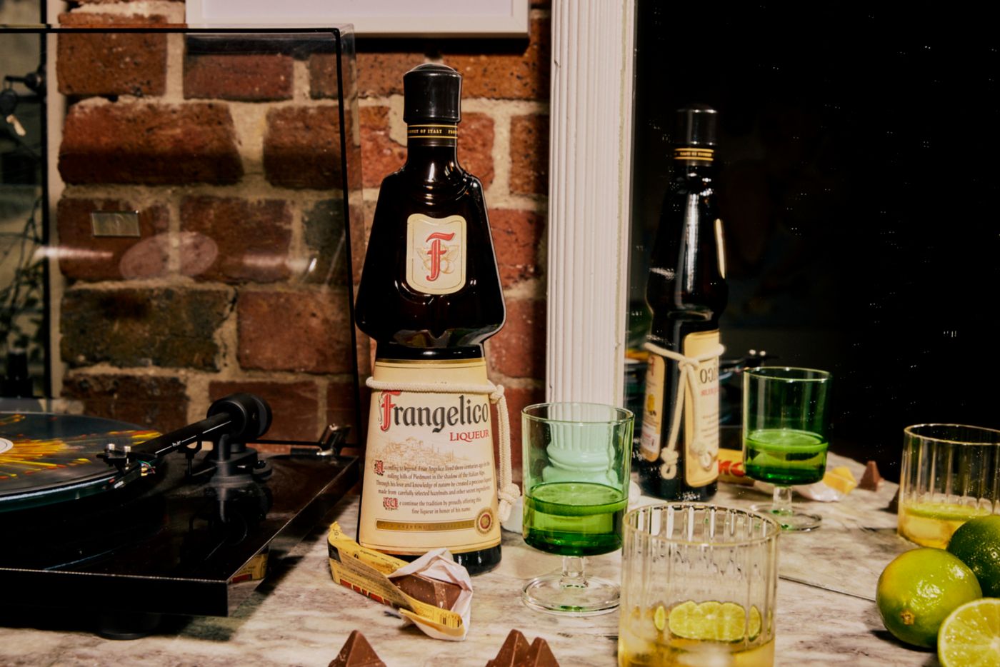 A bottle of Frangelico on a counter with glasses 