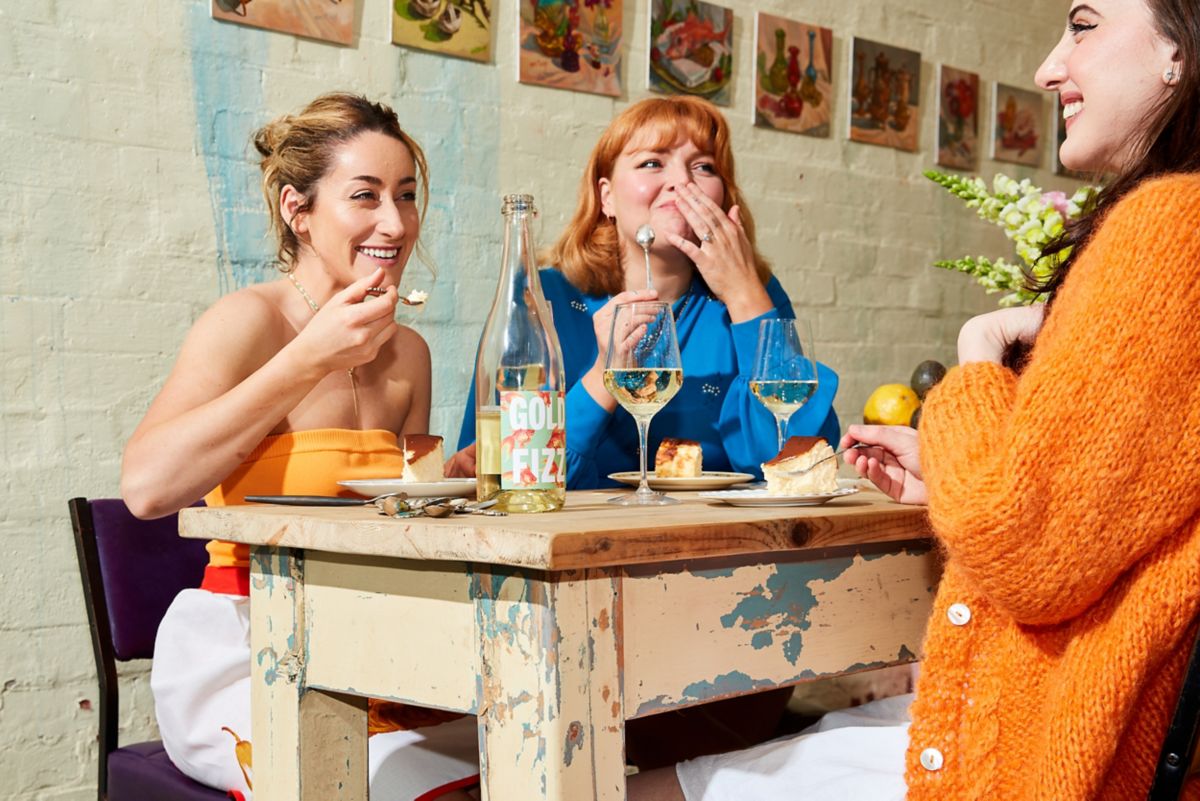 Audrey and friends drinking wine and eating cheesecake