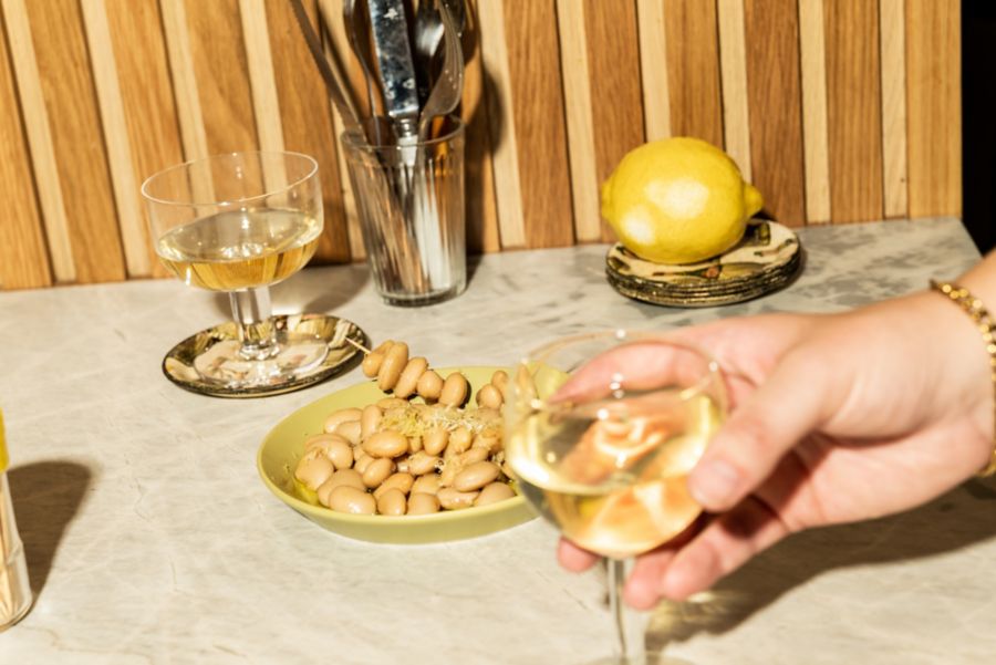 Glasses of white wines with a plate of beans 