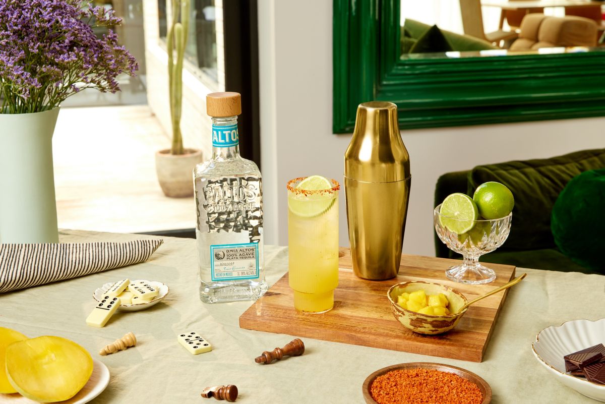 Sunset Cooler cocktail on table with Olmeca Altos Plata Tequila bottle