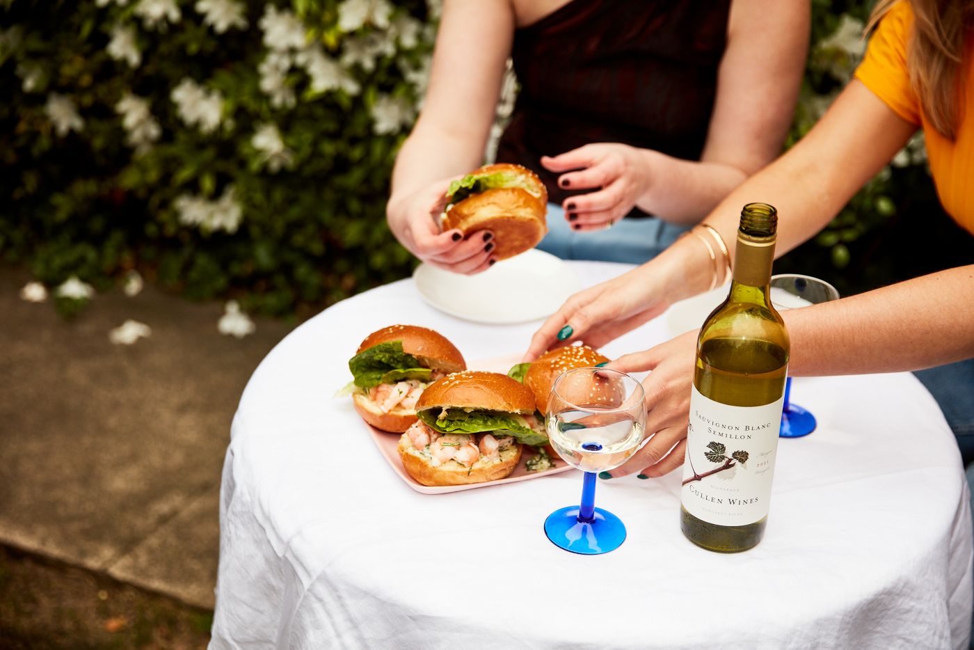 Friends enjoying prawn rolls and a glass of white wine