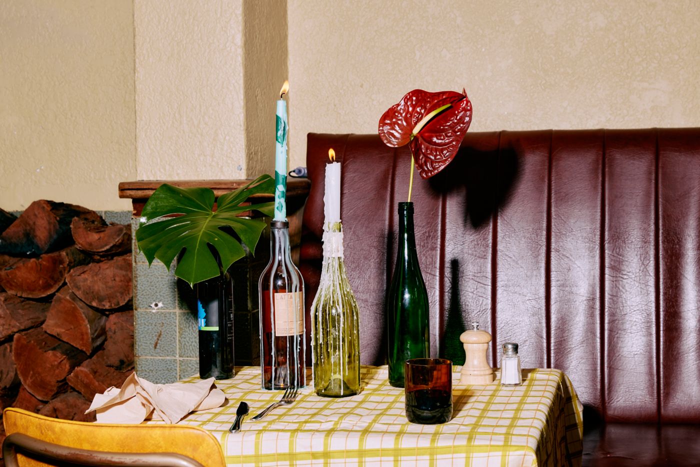 Bottles used as vases and candle holders on a table