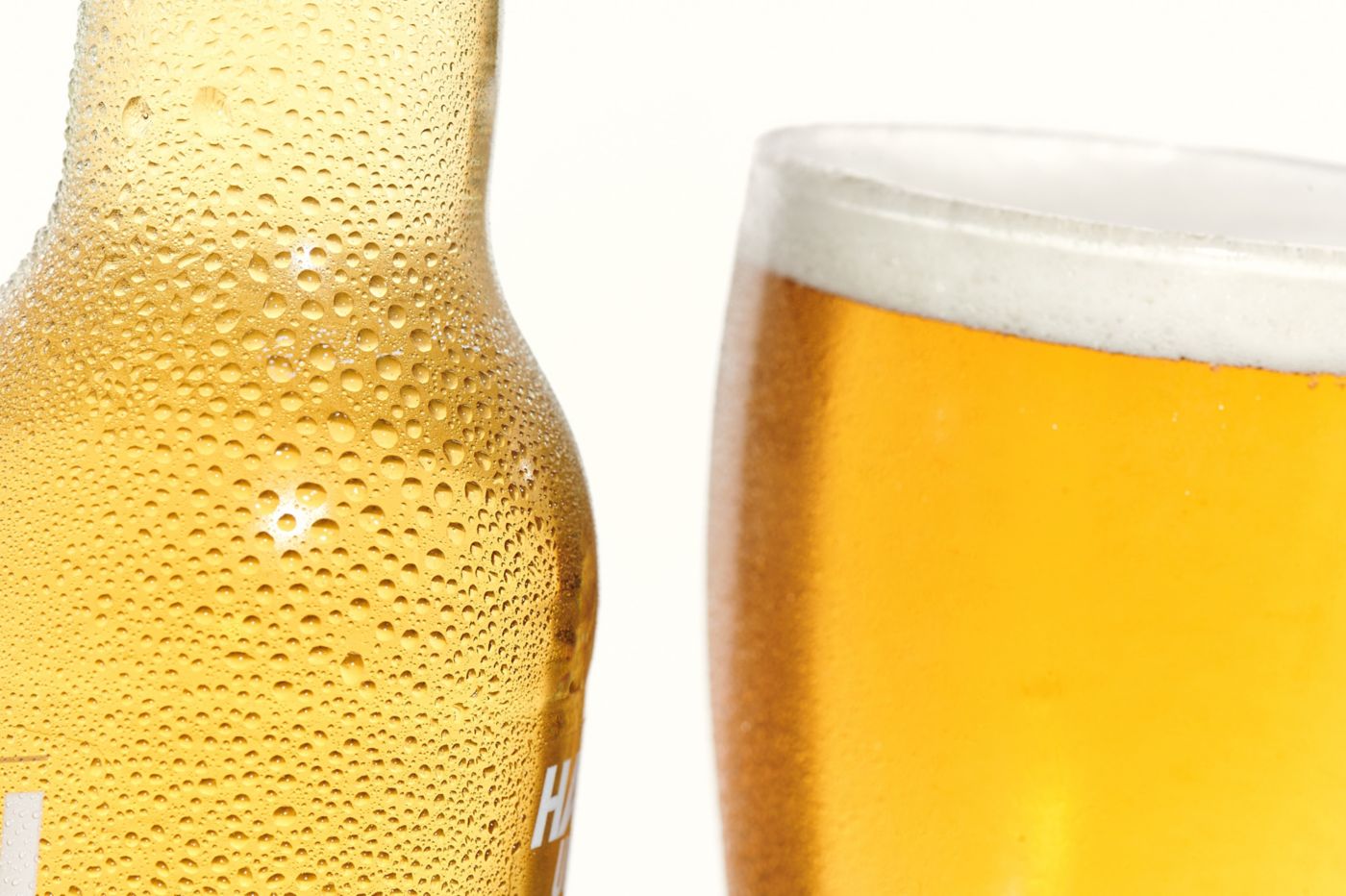 A close-up of two cold beers – one in a bottle and the other in a glass  