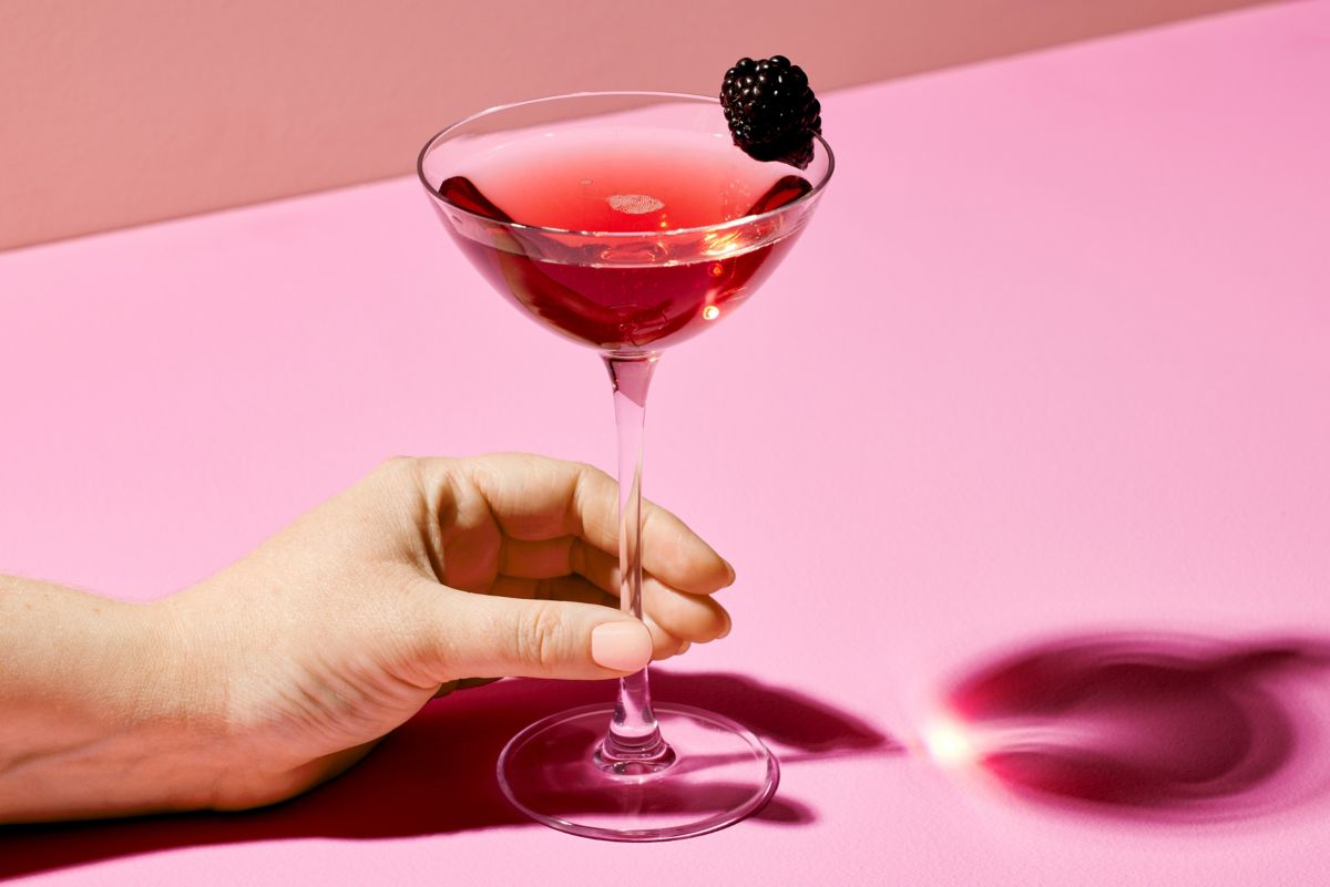 Holding the stem of the Chambord Royale cocktail