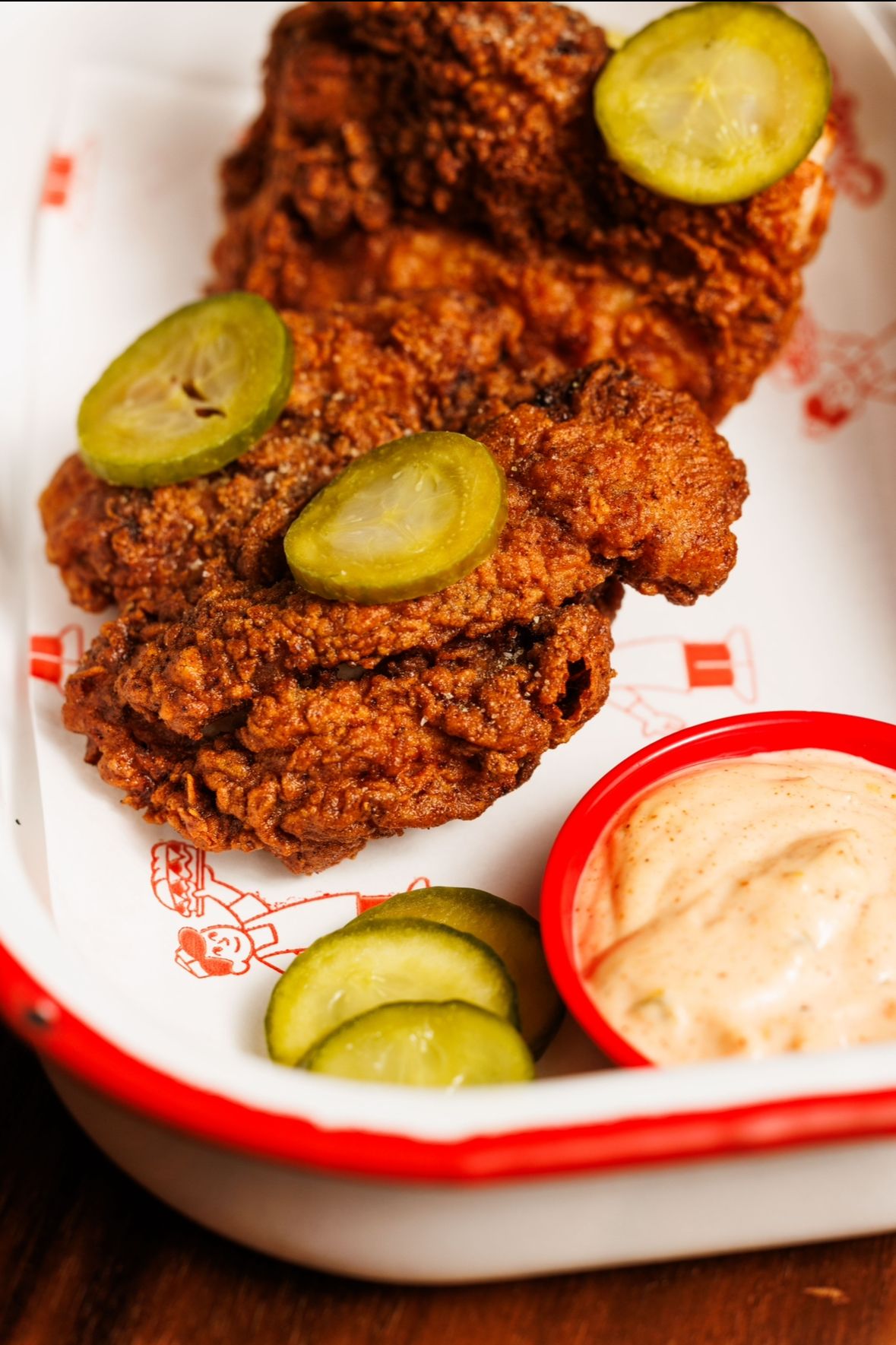 Fried chicken served with pickles and sauce at JollyGood in Melbourne