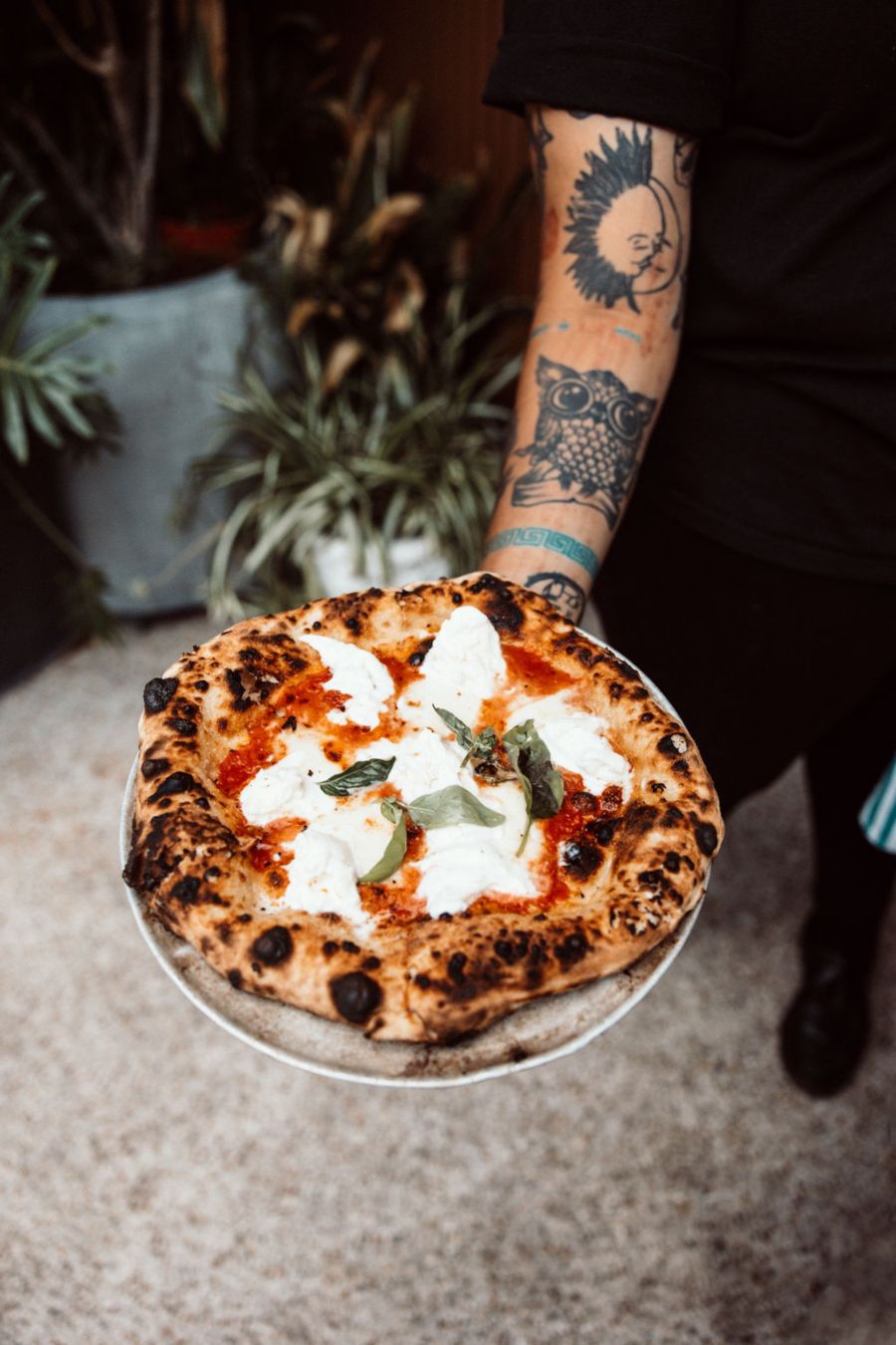 Tattooed Hand Holding pizza plate