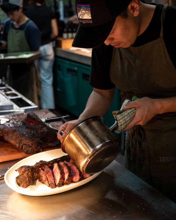Chef serving meat at Terra in Canberra