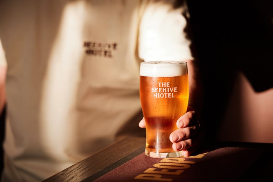 Holding a pint of beer on the bar at The Beehive Hotel 