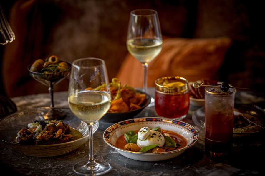 Various dishes with white wine at Bar Conexao in Melbourne's Eltham