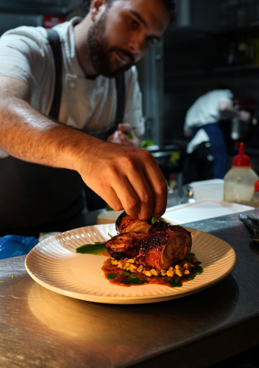 Finalising a dish in the kitchen at Adelita