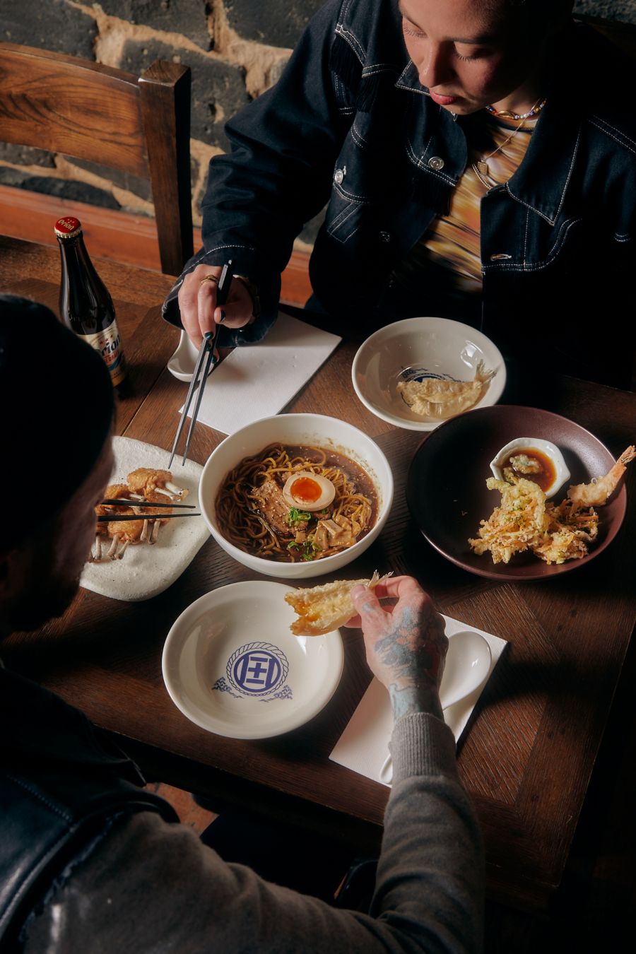 people enjoying drinks and food at Izakaya by Tamura