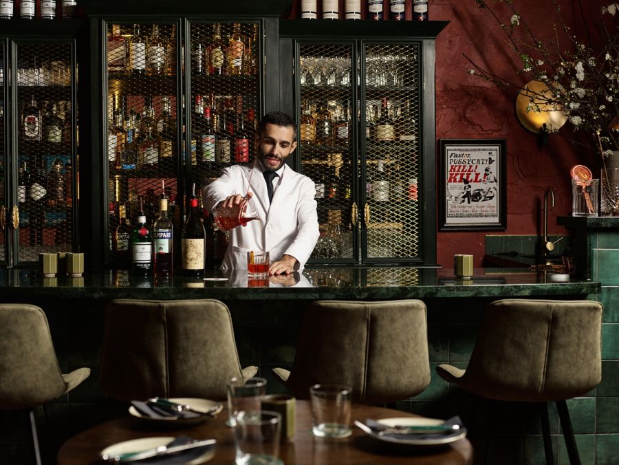 A bartender mixing a drink at Bar Conte