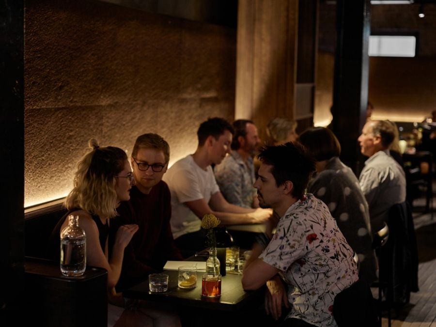 Customers enjoying food and drinks at Four Pillars Gin