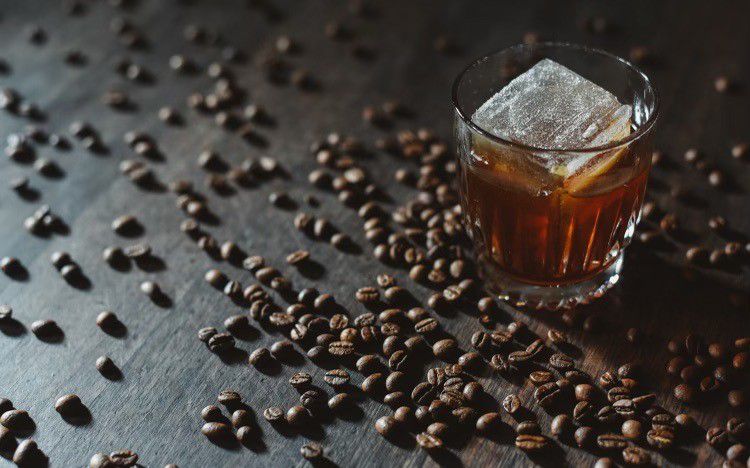 A cocktail with coffee beans on the table
