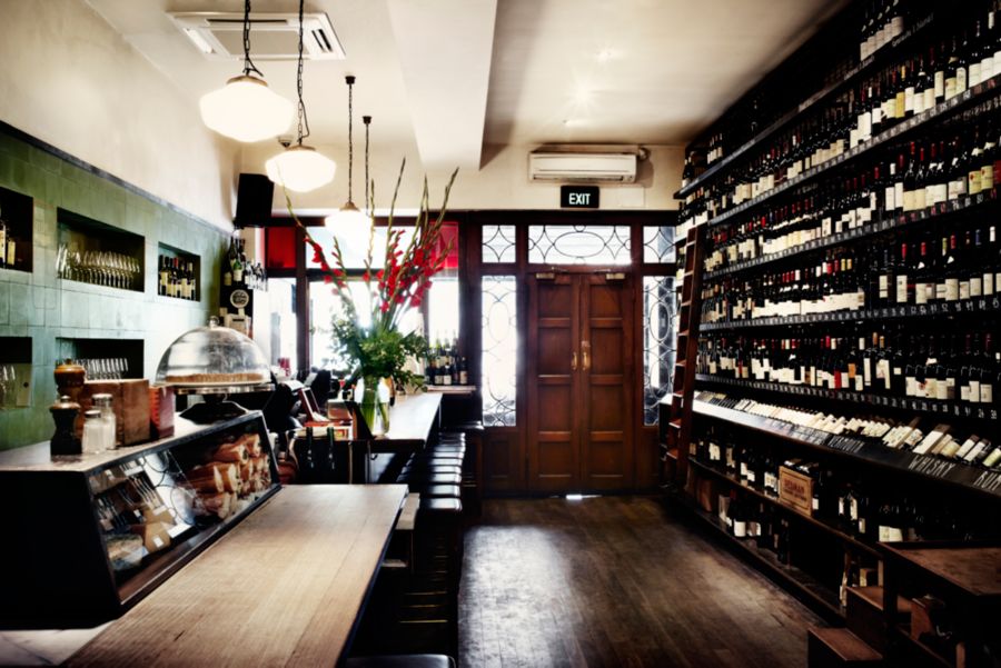 Inside City Wine Shop, with the walls lined with bottles
